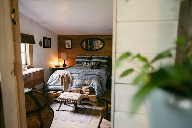 bedroom with wood walls and wood finished floors