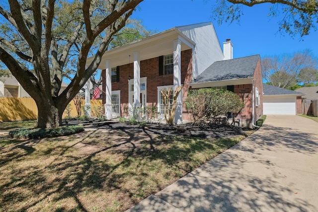 neoclassical home with fence, a porch, a chimney, a garage, and brick siding