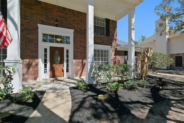 doorway to property with brick siding and a porch