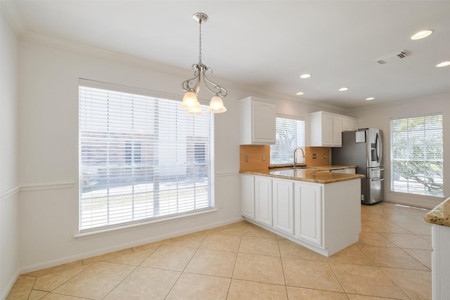 kitchen with visible vents, light stone countertops, a peninsula, stainless steel refrigerator with ice dispenser, and white cabinets