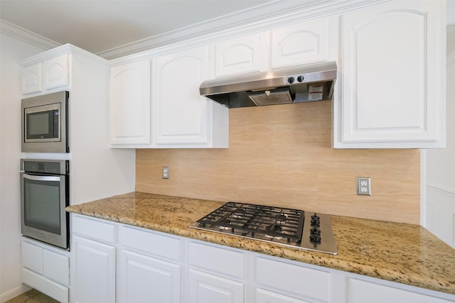 kitchen with under cabinet range hood, white cabinetry, stainless steel appliances, and tasteful backsplash