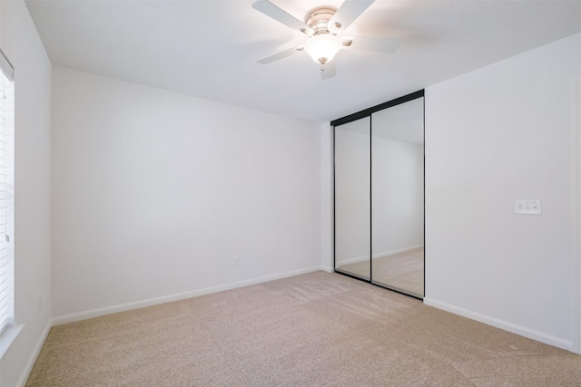 unfurnished bedroom featuring a closet, baseboards, carpet, and a ceiling fan