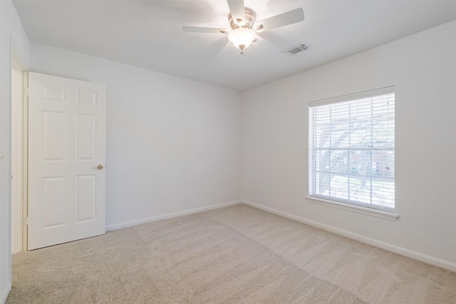 spare room with visible vents, baseboards, ceiling fan, and carpet floors