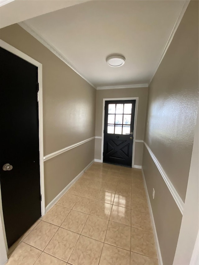 entryway featuring crown molding, baseboards, and light tile patterned floors