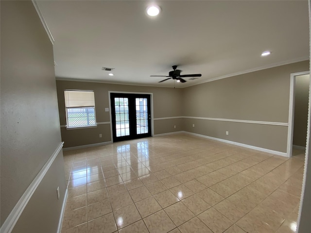 empty room with light tile patterned flooring, visible vents, baseboards, french doors, and crown molding