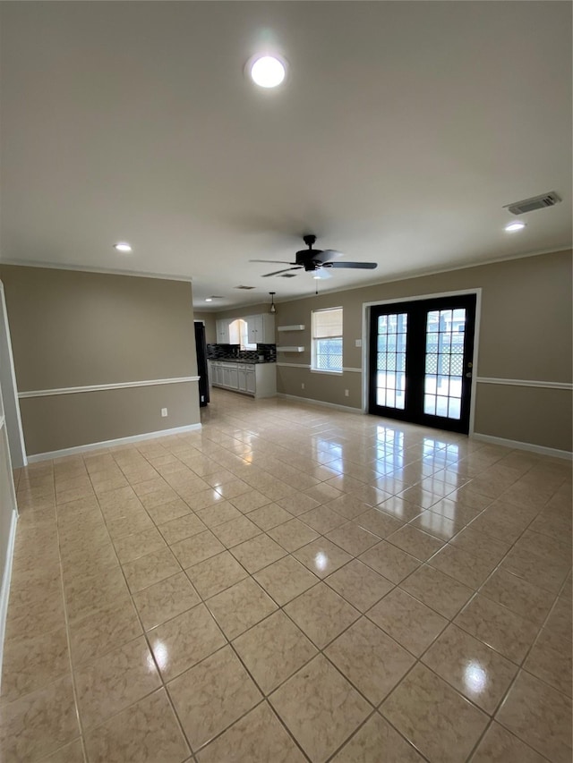 unfurnished living room featuring french doors, visible vents, a ceiling fan, light tile patterned flooring, and baseboards