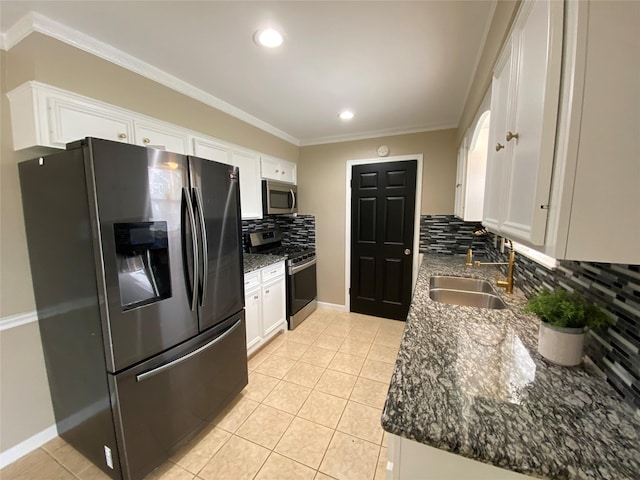 kitchen with light tile patterned floors, stainless steel appliances, a sink, and white cabinets