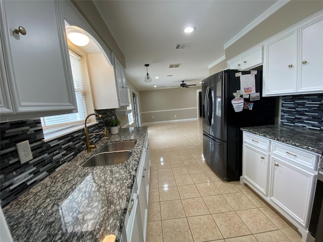 kitchen featuring freestanding refrigerator, visible vents, a sink, and light tile patterned flooring