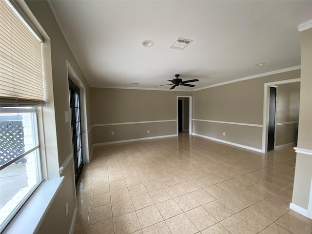 spare room featuring light tile patterned floors, baseboards, visible vents, and ornamental molding