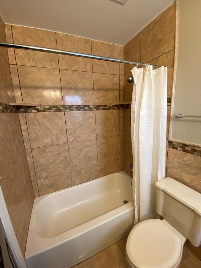 full bathroom featuring toilet, shower / bath combination with curtain, and tile walls