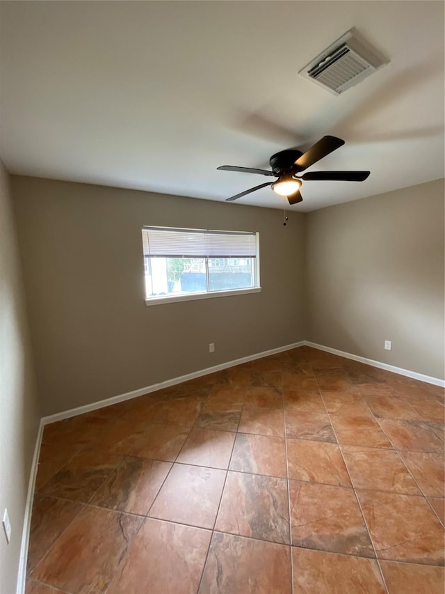 empty room featuring baseboards, visible vents, and a ceiling fan