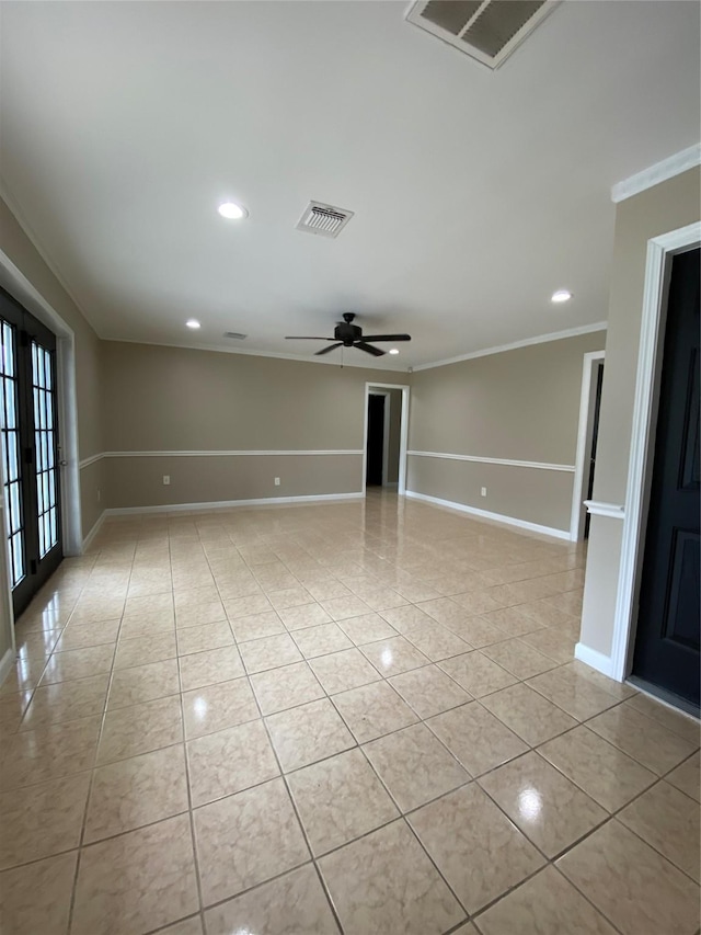 spare room with light tile patterned floors, baseboards, visible vents, and crown molding