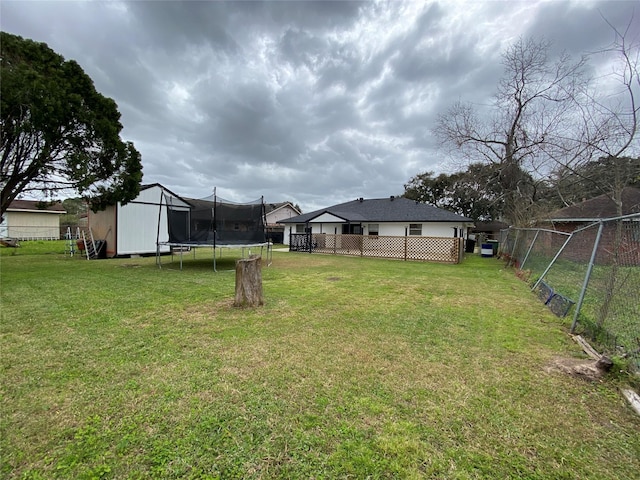 view of yard with an outbuilding, a storage shed, a trampoline, and a fenced backyard