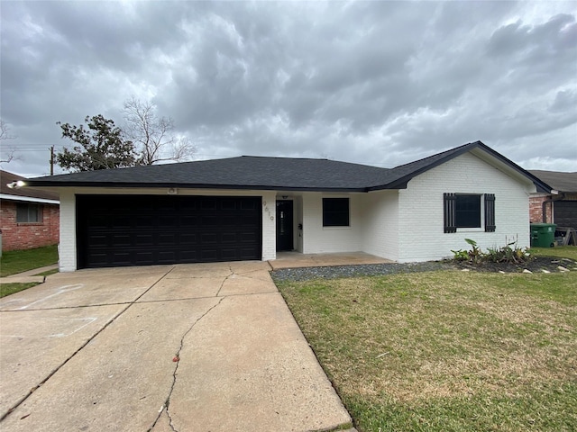 single story home with brick siding, roof with shingles, concrete driveway, an attached garage, and a front lawn