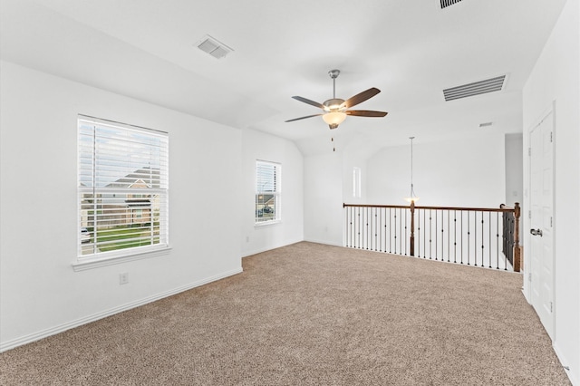 unfurnished room with ceiling fan, visible vents, vaulted ceiling, and carpet flooring