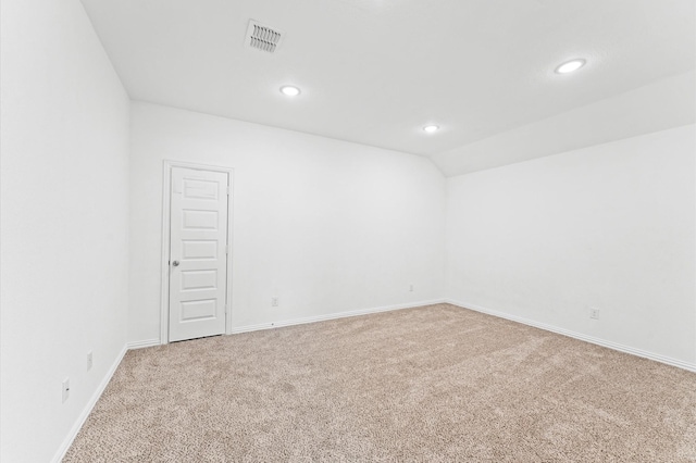 carpeted spare room with baseboards, visible vents, vaulted ceiling, and recessed lighting