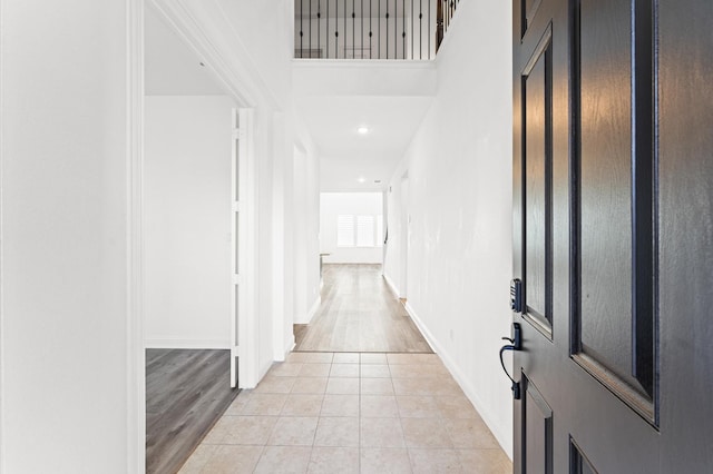 hallway with baseboards and light tile patterned floors