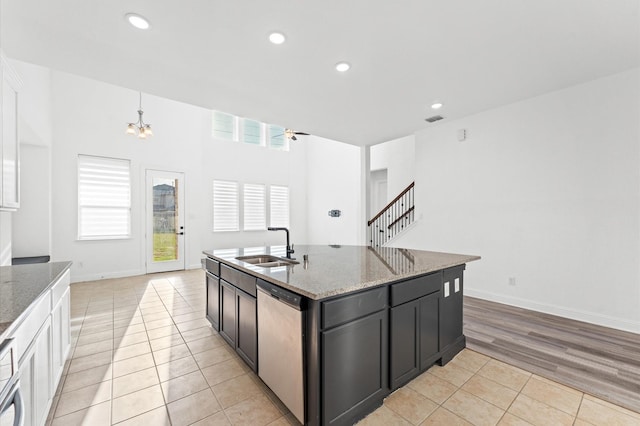 kitchen with a sink, plenty of natural light, dishwasher, and light tile patterned flooring