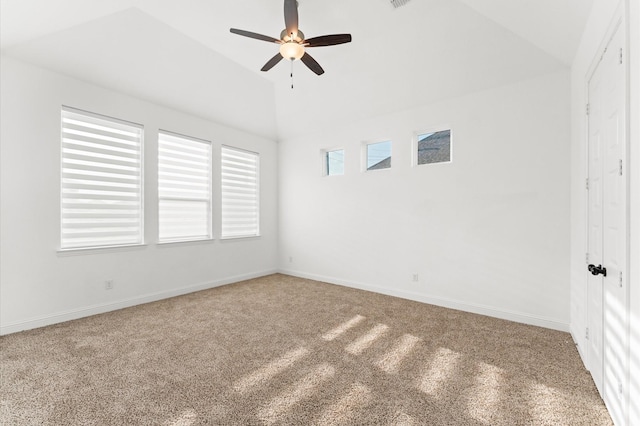 spare room with carpet floors, visible vents, a ceiling fan, vaulted ceiling, and baseboards