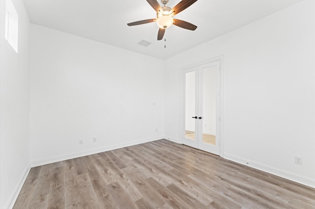 spare room featuring ceiling fan, wood finished floors, visible vents, and baseboards