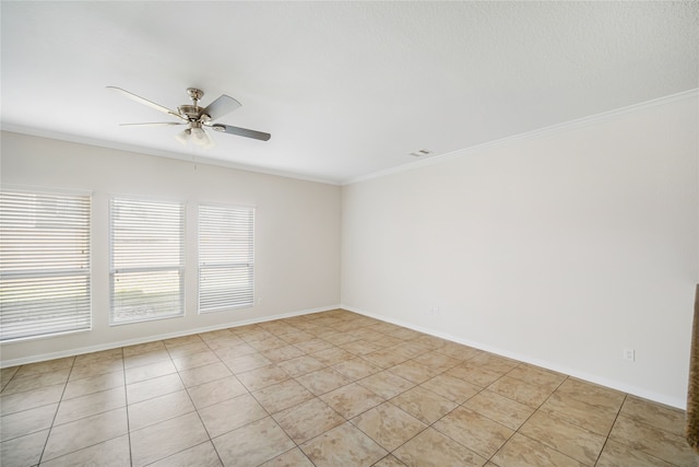 empty room featuring baseboards, ornamental molding, visible vents, and a ceiling fan