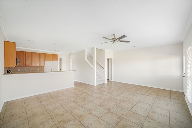 unfurnished living room with light tile patterned floors, stairway, ornamental molding, a ceiling fan, and baseboards