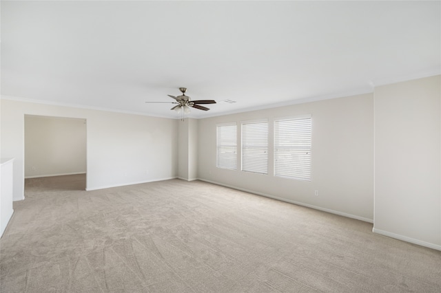 unfurnished room featuring light carpet, crown molding, and baseboards