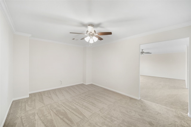 carpeted spare room featuring ceiling fan, baseboards, and crown molding