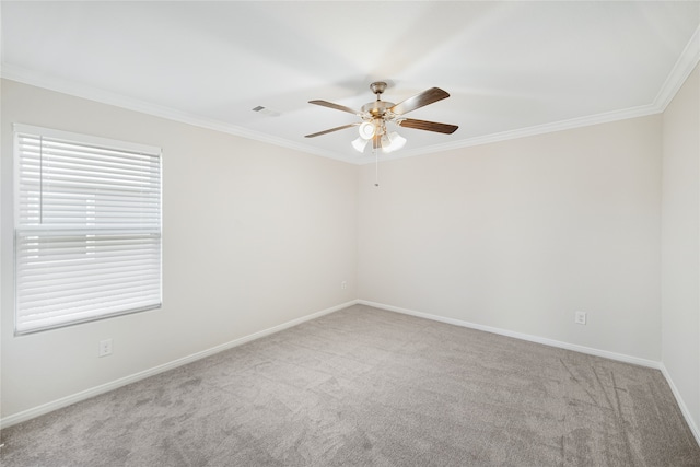 carpeted empty room with baseboards, visible vents, a ceiling fan, and crown molding