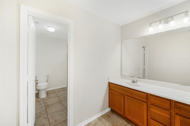 bathroom featuring tile patterned flooring, baseboards, vanity, and toilet