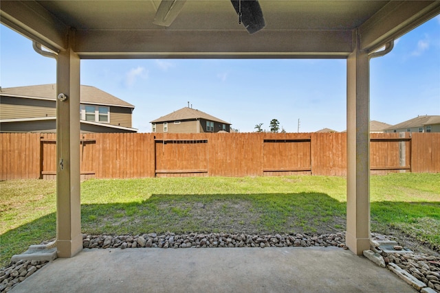 view of yard featuring ceiling fan and a fenced backyard