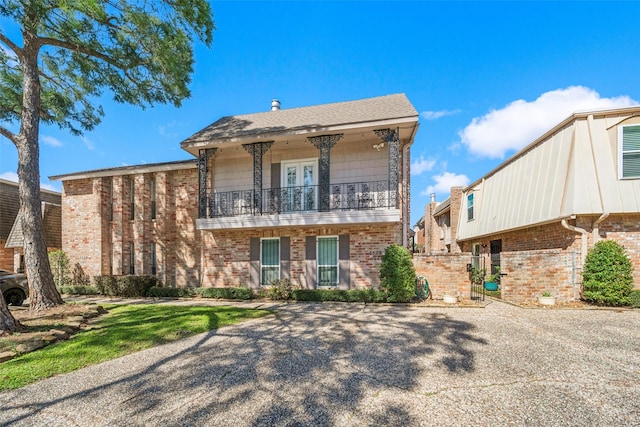 view of front of house with a balcony and brick siding