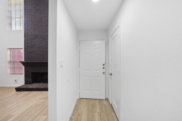 corridor with light wood-style flooring and baseboards