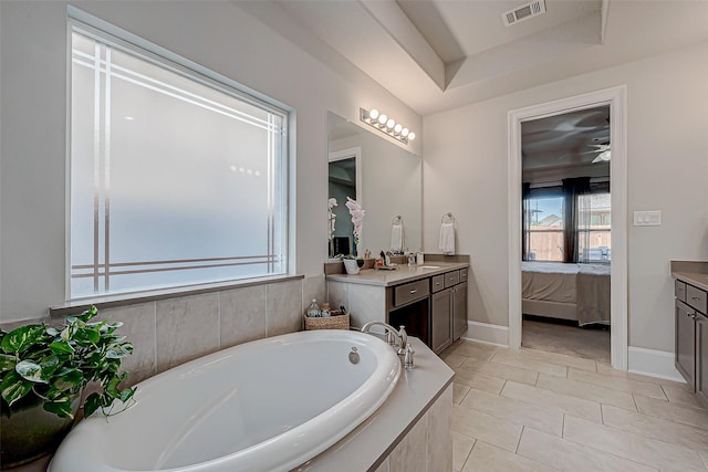 ensuite bathroom with visible vents, connected bathroom, vanity, and a bath