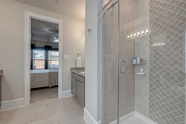 ensuite bathroom with ensuite bathroom, tile patterned flooring, vanity, baseboards, and a stall shower