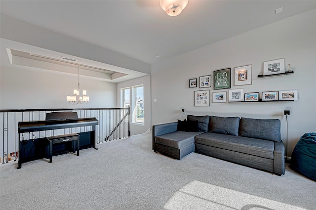 carpeted living area featuring a chandelier, a tray ceiling, and visible vents