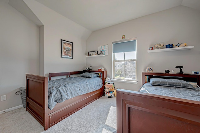 bedroom with light carpet, vaulted ceiling, and baseboards