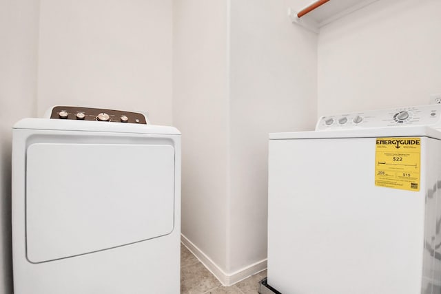 clothes washing area featuring laundry area, washing machine and dryer, and baseboards