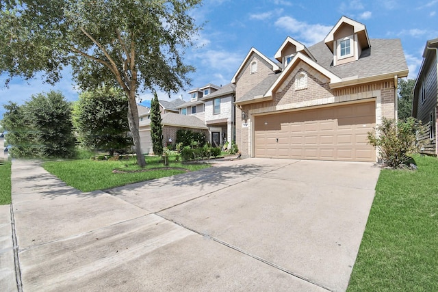 view of front facade with an attached garage, brick siding, a shingled roof, concrete driveway, and a front yard