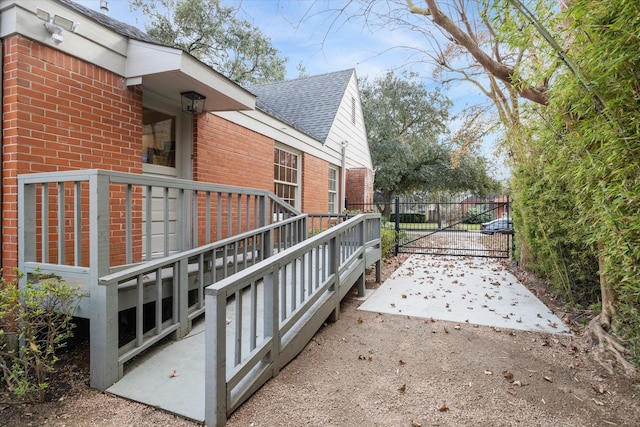 view of home's exterior featuring a shingled roof and brick siding