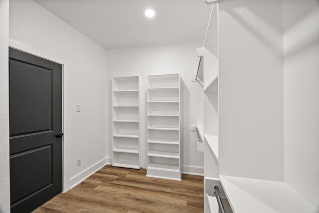 walk in closet with wood finished floors