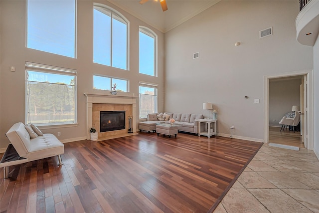 unfurnished living room with wood finished floors, visible vents, and a healthy amount of sunlight