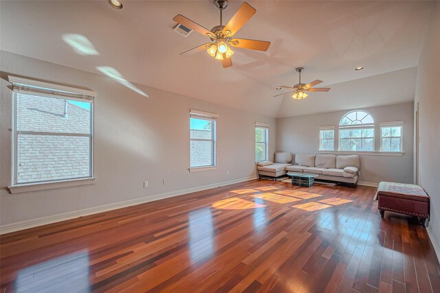 unfurnished living room with dark wood-type flooring, visible vents, vaulted ceiling, and baseboards