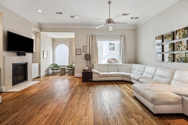 unfurnished living room with a healthy amount of sunlight, crown molding, visible vents, and hardwood / wood-style floors