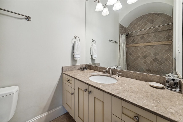 bathroom featuring toilet, vanity, a shower with curtain, baseboards, and tile patterned floors