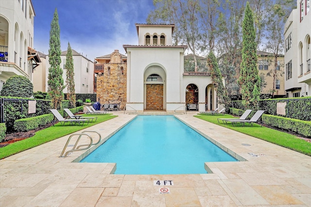 pool with a patio and fence