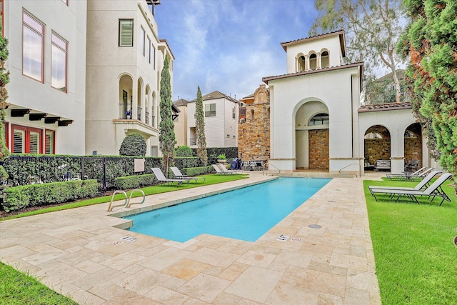 community pool featuring a yard, a patio, and fence