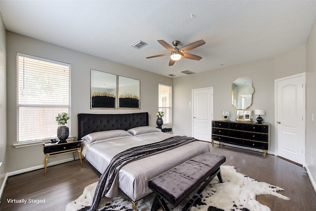 bedroom featuring baseboards, visible vents, and wood finished floors