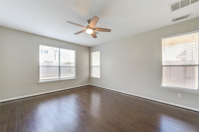 spare room featuring visible vents, wood finished floors, a ceiling fan, and baseboards