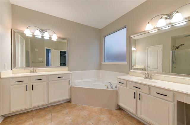 bathroom with tile patterned flooring, two vanities, a sink, and a bath